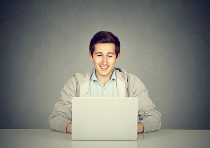快乐的年轻人在便携式计算机上工作