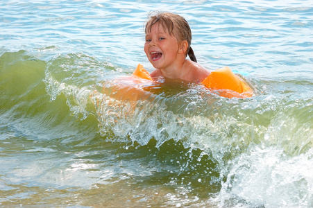 海岸线沐浴小女孩沐浴在波浪中照片