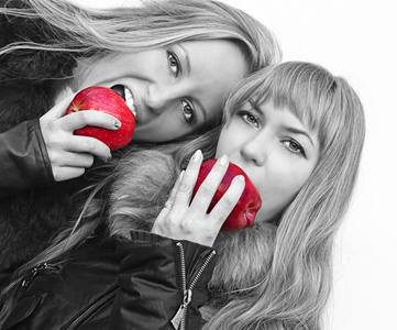 两个有吸引力的年轻女孩吃的苹果