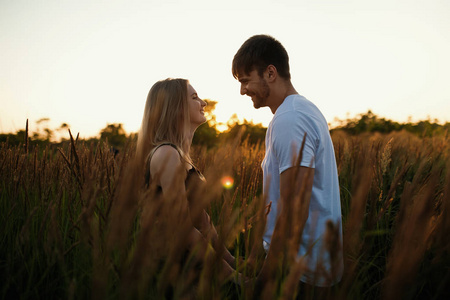 在日出或日落时相爱的两人.男人和女人对场照片