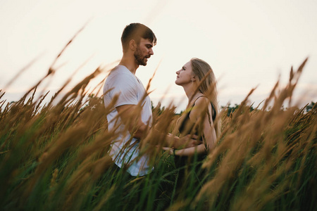 在日出或日落时相爱的两人.男人和女人对场照片