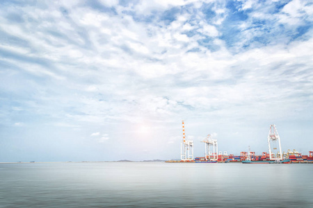 物流导入在蔚蓝的天空海港集装箱货运船起重机出口背景