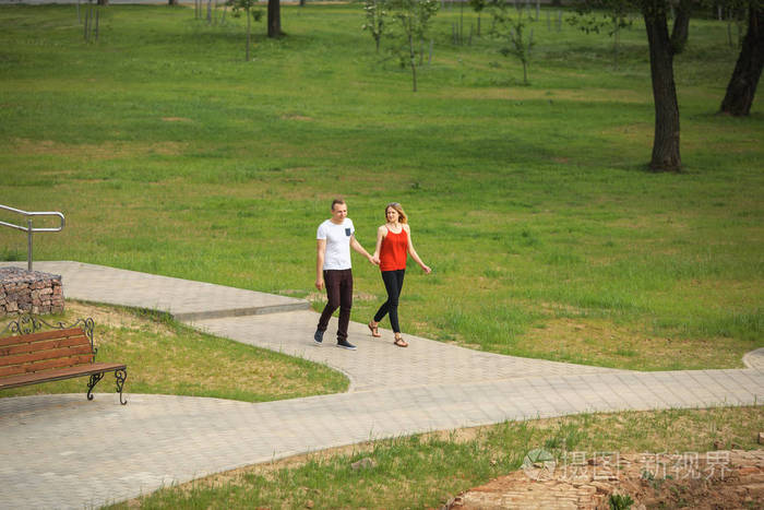 一对情侣在阳光明媚的夏日漫步城市公园.年轻的男孩和女孩.顶视图