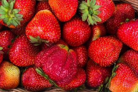 草莓在柳条篮子里木背景