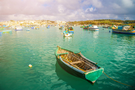 马尔萨什洛克，马耳他传统绿色马耳他 Luzzu fisherboat 在马尔萨什洛克与绿色的海洋水，蓝色的天空和棕榈树的一个夏