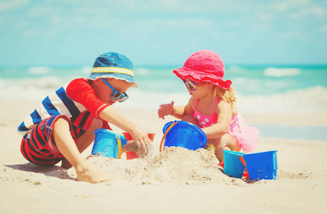 小男孩和女孩在沙滩上玩沙