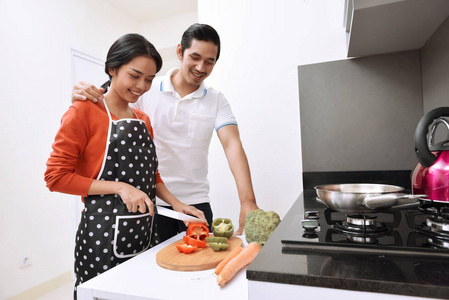 亚洲夫妇微笑和一起煮饭的肖像
