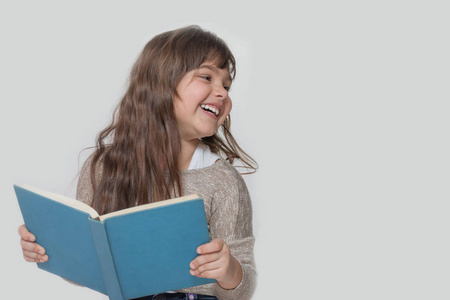 微笑的小女孩，读一本书的肖像