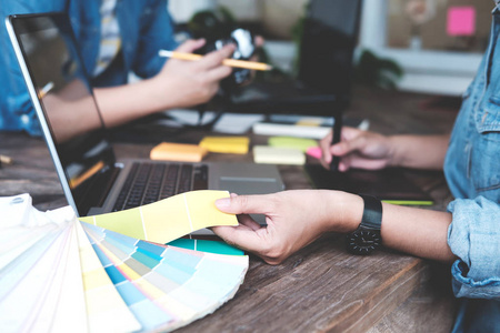 年轻的摄影师和平面设计师在工作室办公室工作照片