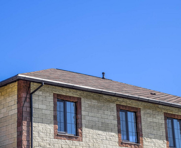 梯形砖这房子是用米色砖做的, 屋顶上布满了沥青瓦.