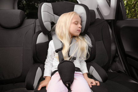 金发女孩睡在儿童安全座椅