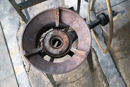 大型天然气火盆, 老人和垃圾大老式燃气灶在地板上照片