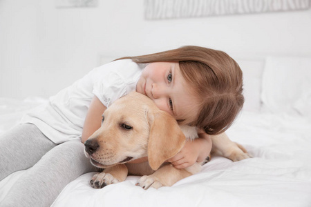 可爱的孩子与拉布拉多犬在床上