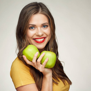 微笑的女士拿着两个绿色的苹果