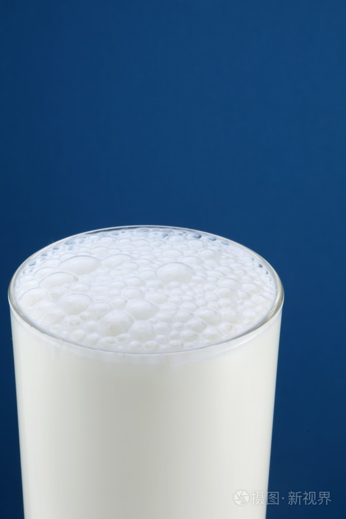 蓝色背景上的一杯牛奶