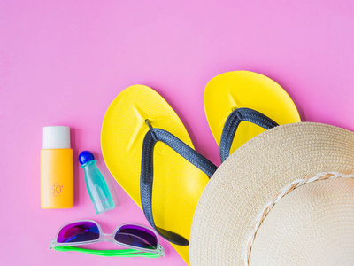 与夏天的帽子，太阳镜翻转翻牌，洗发水和防晒霜洗剂对粉红色背景。假期和松弛，夏天旅游概念