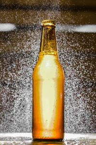关闭与模糊背景上空气中的水泡沫工艺啤酒一瓶