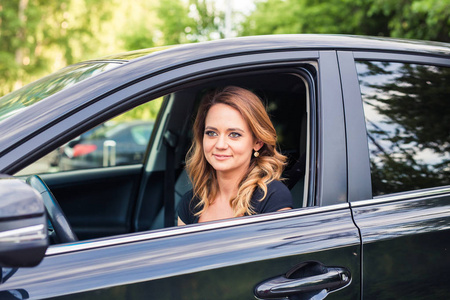 微笑的年轻女子，驾驶一辆汽车的肖像