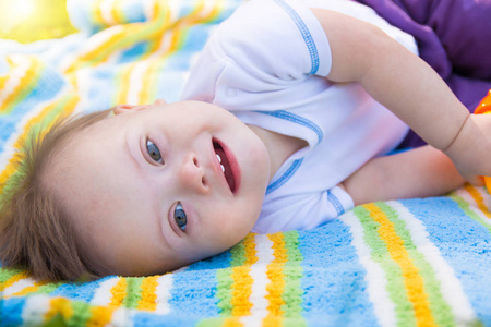 可爱的小宝贝男孩患有唐氏综合症在性质上的夏天躺在毯子上的肖像