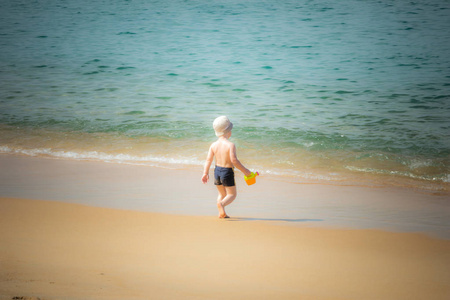 在沙滩上玩耍的小男孩复古风格