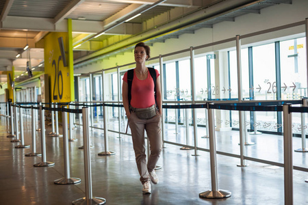年轻女人提着行李在机场大厅里等待她的飞机