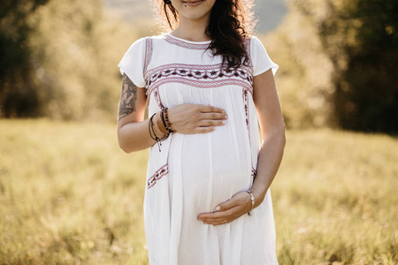 一个怀孕的女人抱着她的肚子的裁剪图像