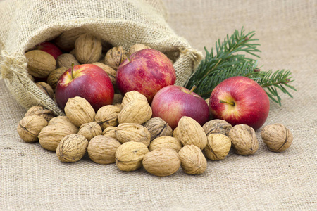 麻布袋充满整个核桃和苹果图片