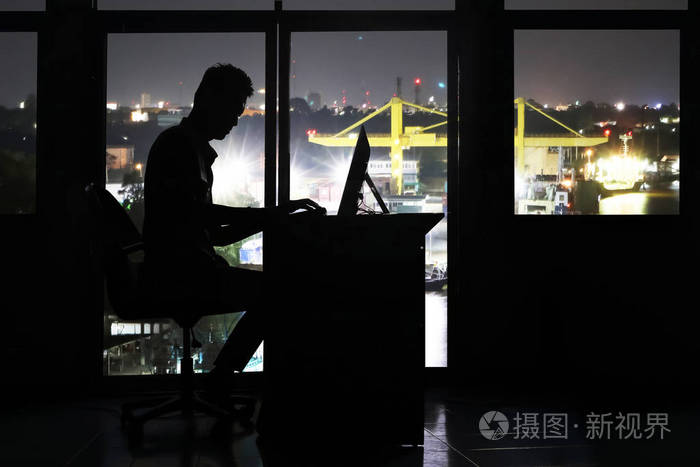 夜间工作在办公室计算机上的商人