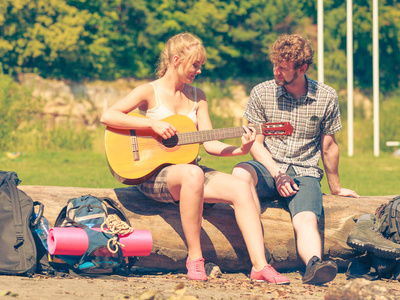 对年轻的夫妇户外野营玩吉他