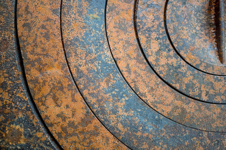 金属带几何孔圈和纹理的铁锈橙棕色具斑点的抽象背景照片