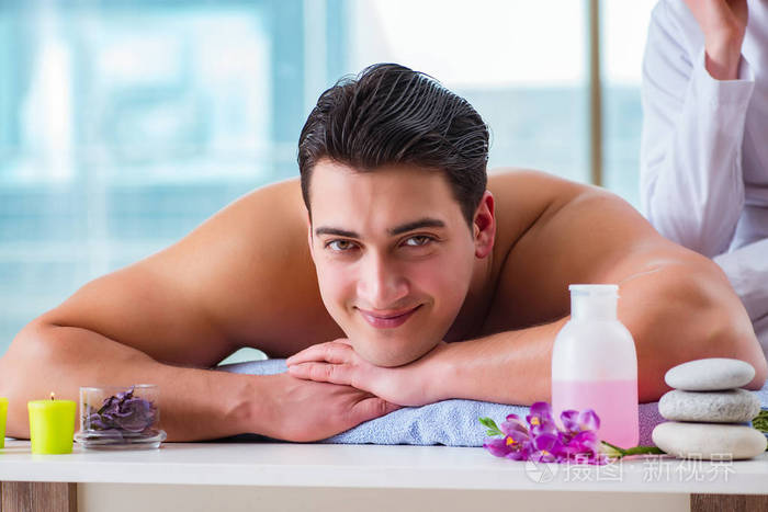 英俊的男人在水疗按摩概念