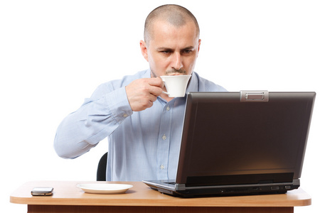 年轻的商人与咖啡和便携式计算机