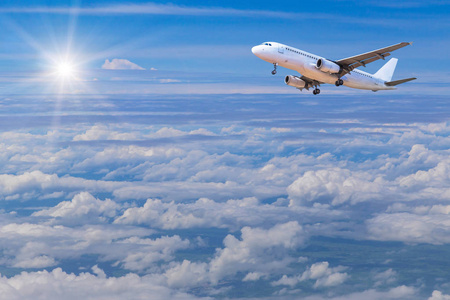 白色的商用飞机，飞向天空高海拔洁白的云朵与阳光中
