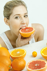 吃葡萄柚的年轻女人的画像
