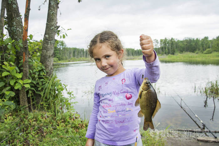 在夏天在钓鱼小女孩抓到一条大鲤鱼