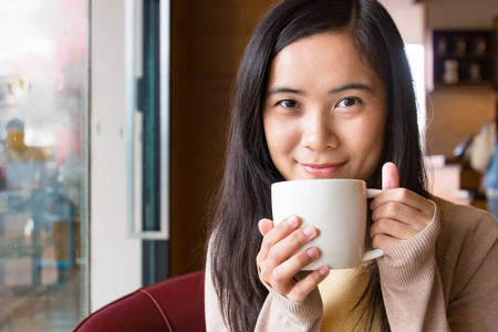 亚洲女子在咖啡厅里喝咖啡