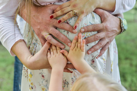 女男和婴儿手中的使形状可爱登录裸腹的孕妇妈妈的心照片