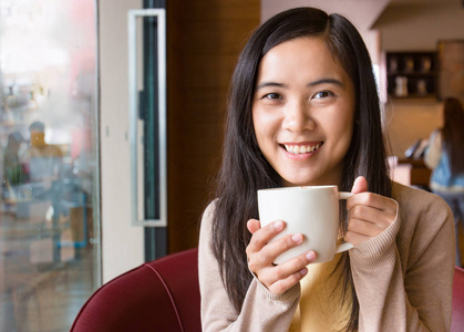 亚洲女子在咖啡厅里喝咖啡