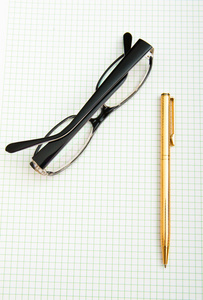 纸上的钢笔和眼镜