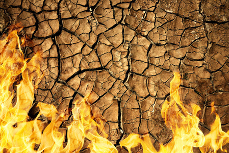 裂干燥土壤的地球纹理与火火焰图片