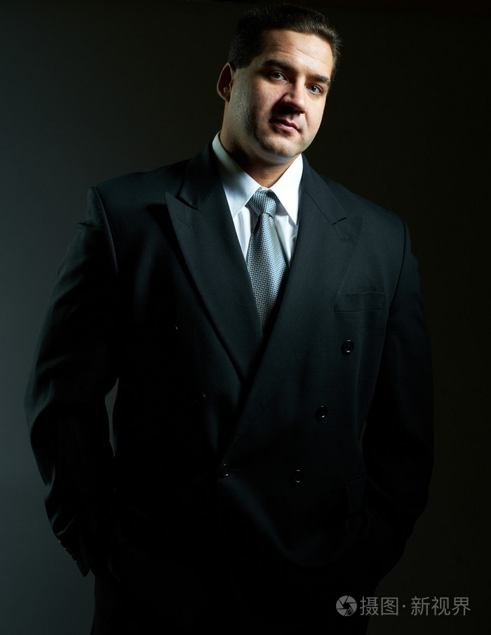 穿黑色西装的英俊时髦年轻人的深色肖像