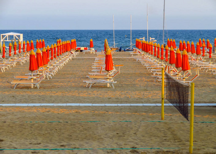 里米尼橙色遮阳伞和日光浴浴床