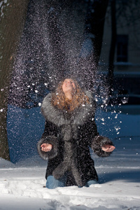 美丽的女人在下雪的冬夜尽情享受