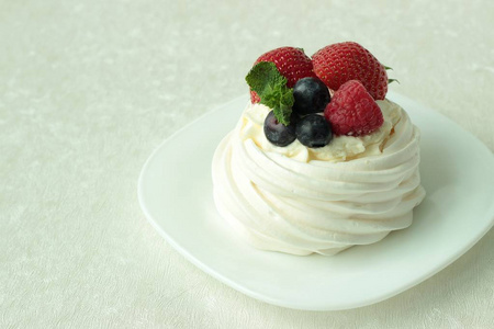 帕夫洛娃酥皮蛋糕与新鲜浆果白色背景上