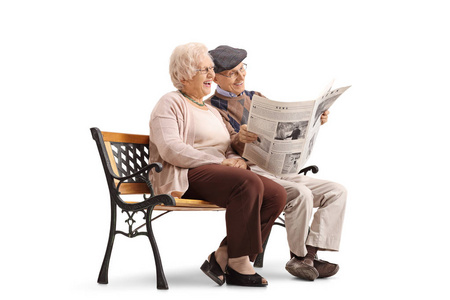 年长的夫妇坐在长椅上，看报纸
