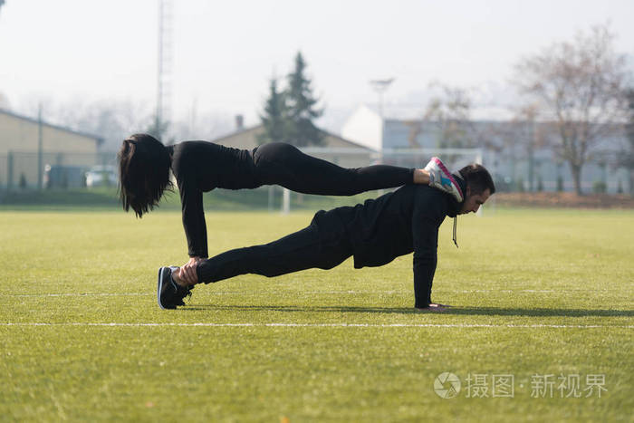 有吸引力的情侣在公园里做俯卧撑