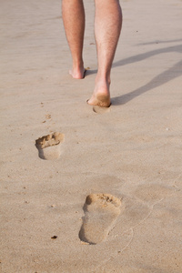 一个人在湿沙中行走的脚印图片
