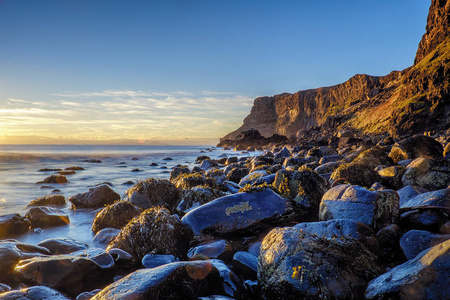 自恃湾巨石和日落时的悬崖图片