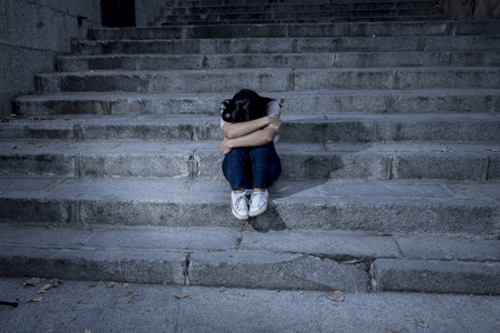 绝望和沮丧的坐在城市街道楼梯上照片