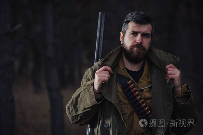 大胡子的猎人与专业设备走在丛林中